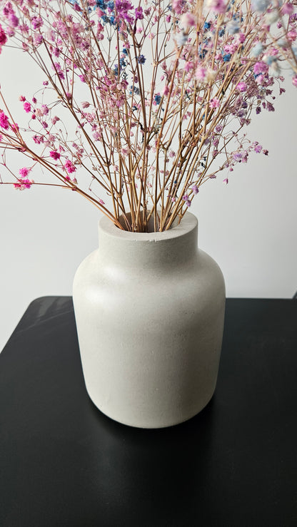 betoninė vaza ant juodo paviršiaus baltame fone