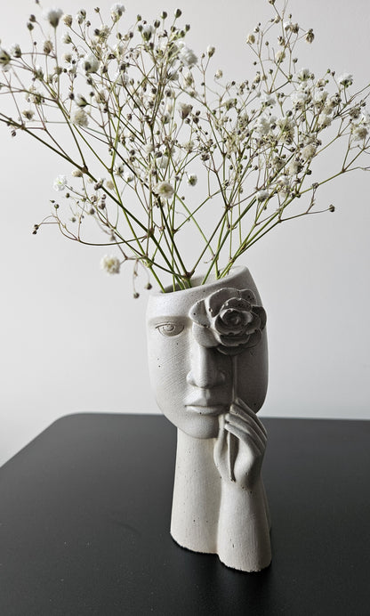 Dekoratyvinė betono vaza veido formos su gėle, moderniam namų interjerui