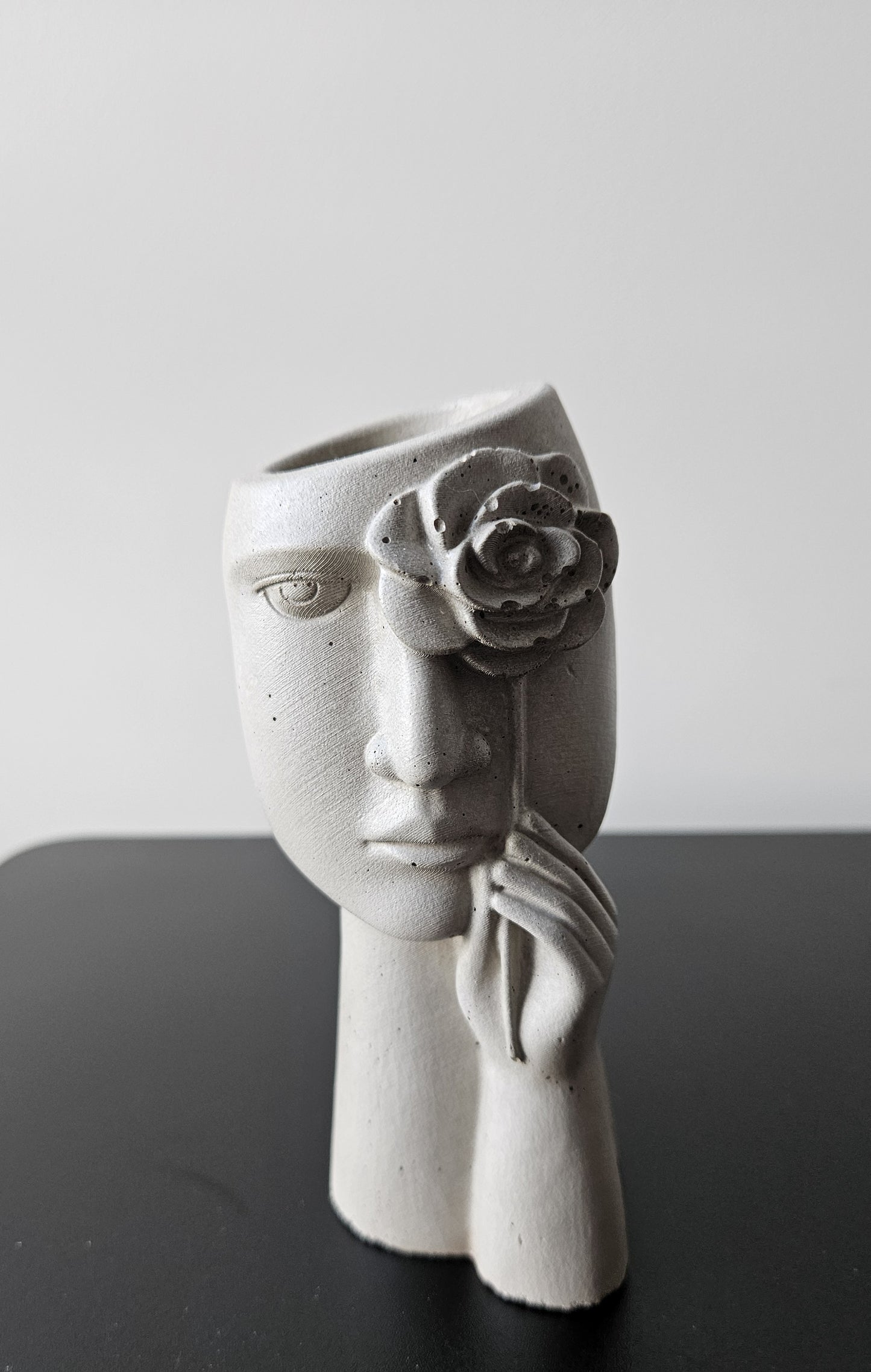 betoninė vaza su moters veidu ir rožės žiedu tinkama naudoti stabilizuotiems sausiems augalams