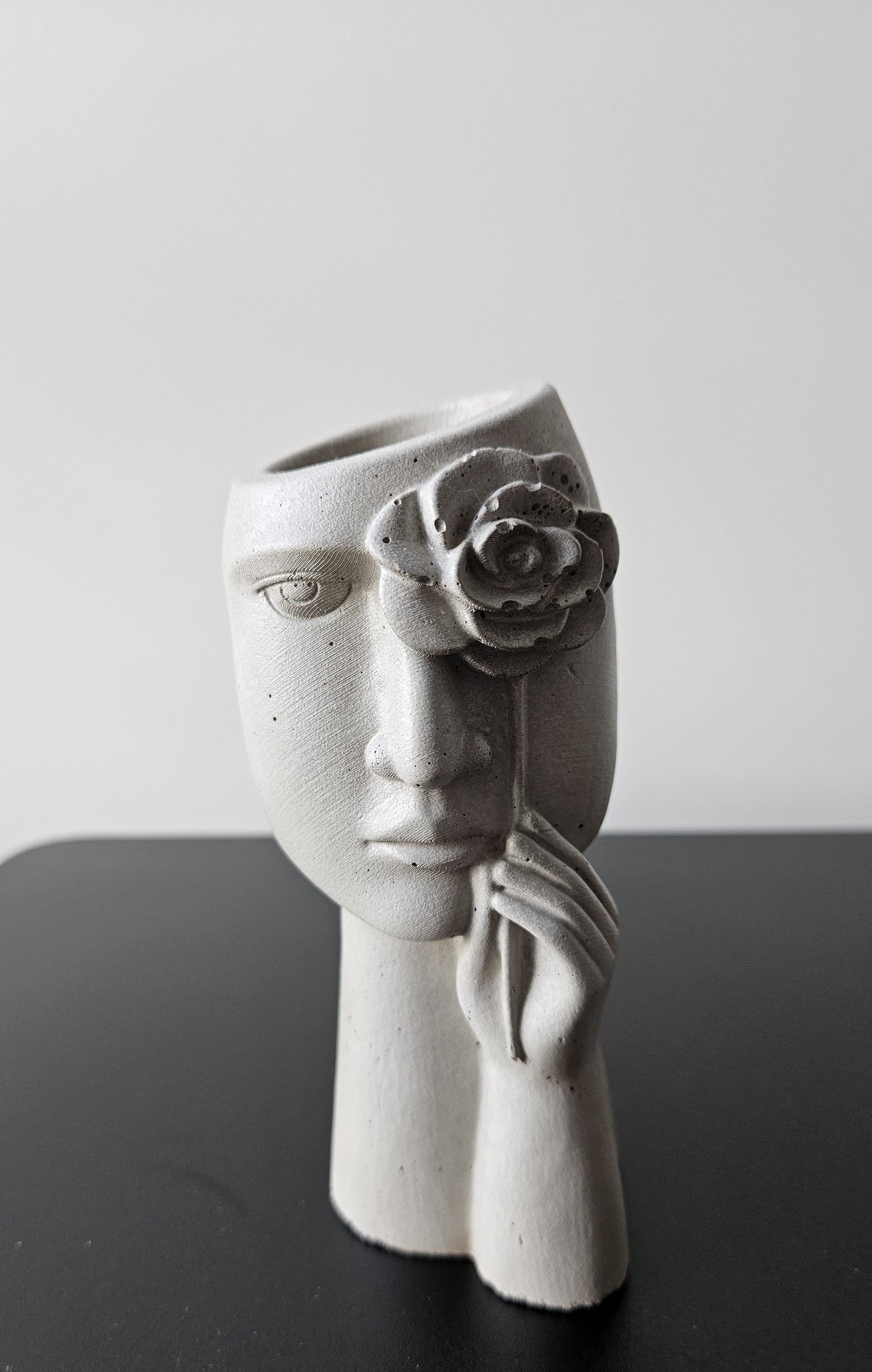 betoninė vaza su moters veidu ir rožės žiedu tinkama naudoti stabilizuotiems sausiems augalams