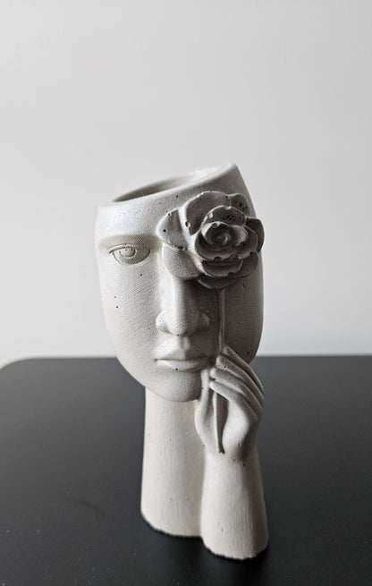 betoninė vaza su moters veidu ir rožės žiedu tinkama naudoti stabilizuotiems sausiems augalams