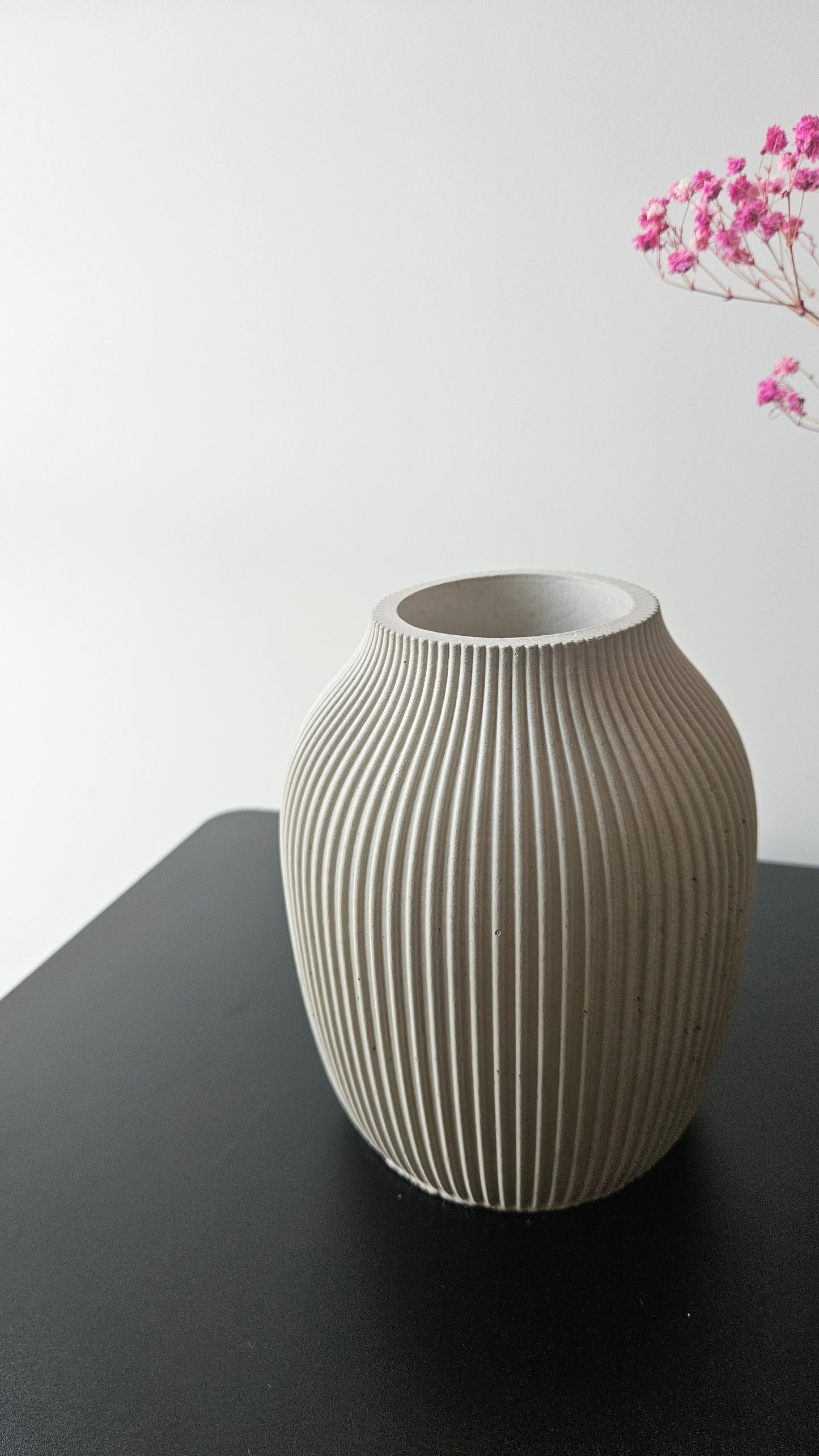 Textured vase on a gray surface with a light gray background