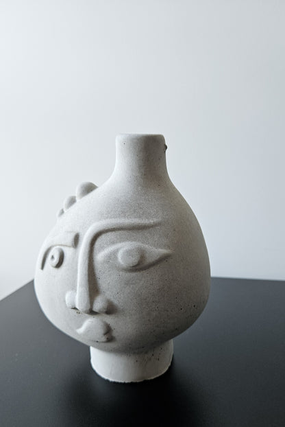 Rankų darbo betoninė vazelė su žmogaus veido reljefu ir sausomis gėlėmis – minimalistinė interjero detalė, tinkanti moderniam ir wabi-sabi stiliaus namų dekorui