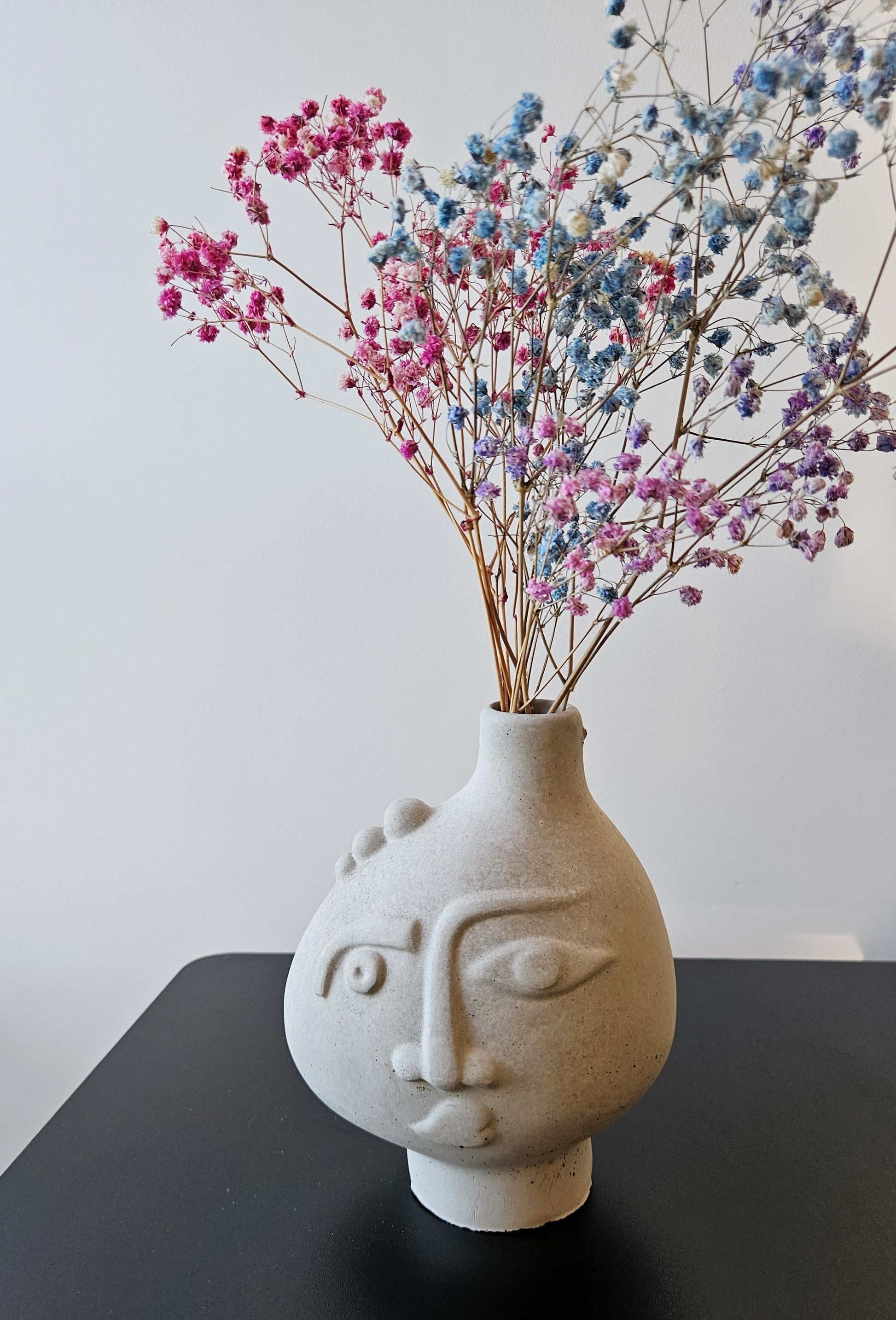Rankų darbo betoninė vazelė su žmogaus veido reljefu ir sausomis gėlėmis – minimalistinė interjero detalė, tinkanti moderniam ir wabi-sabi stiliaus namų dekorui