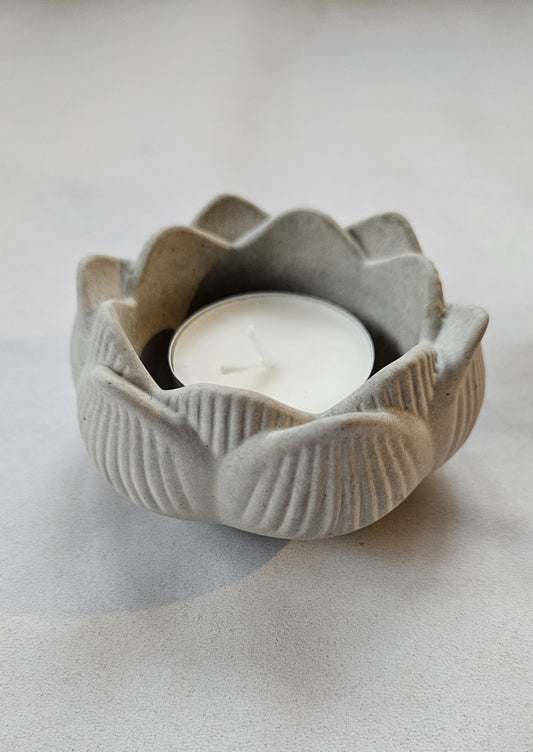 pilka betoninė žvakidė lotosas ant pilko fono