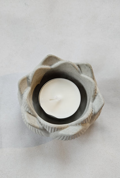 pilka betoninė žvakidė lotosas ant pilko fono