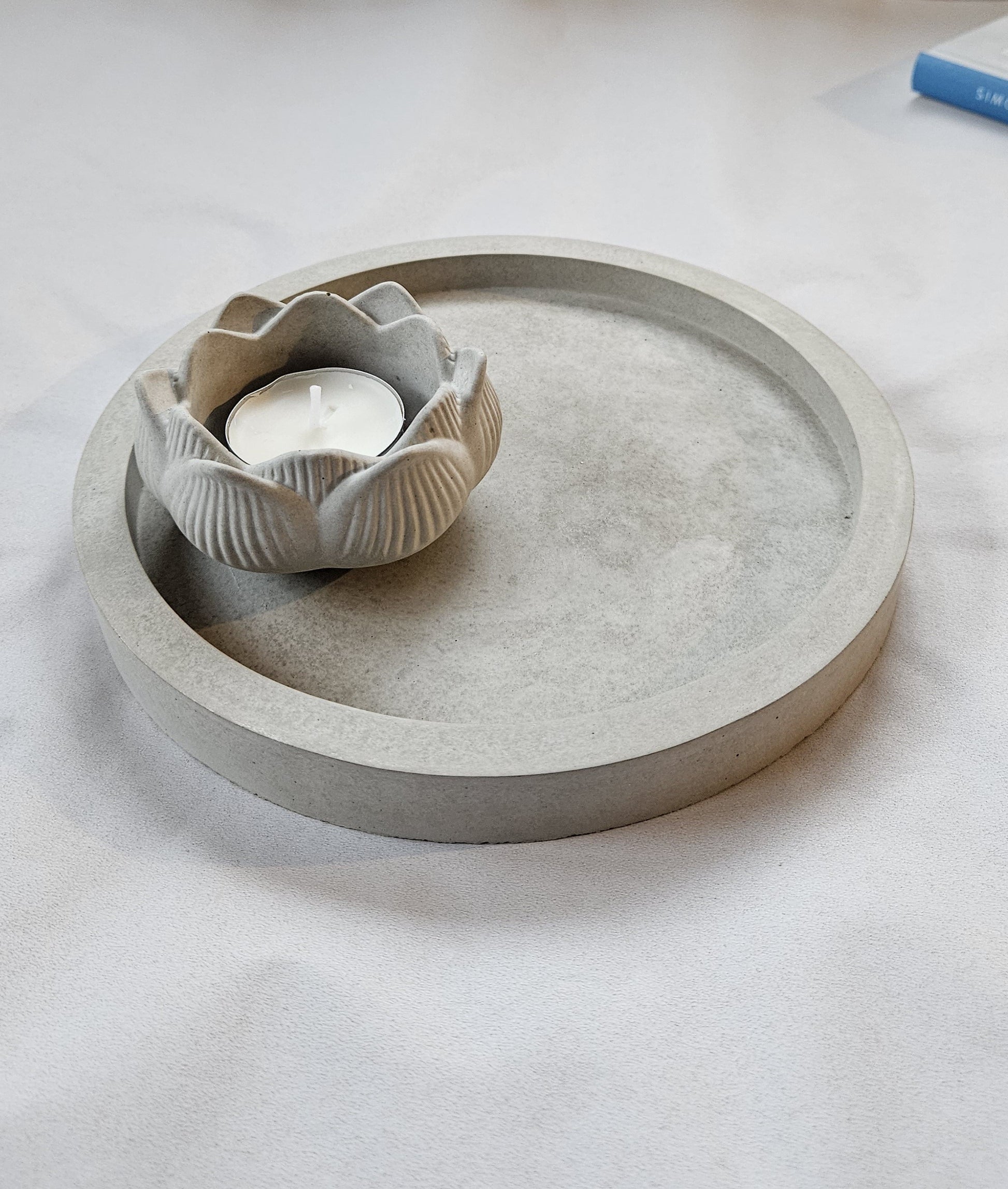 pilka betoninė žvakidė lotosas ant pilko fono