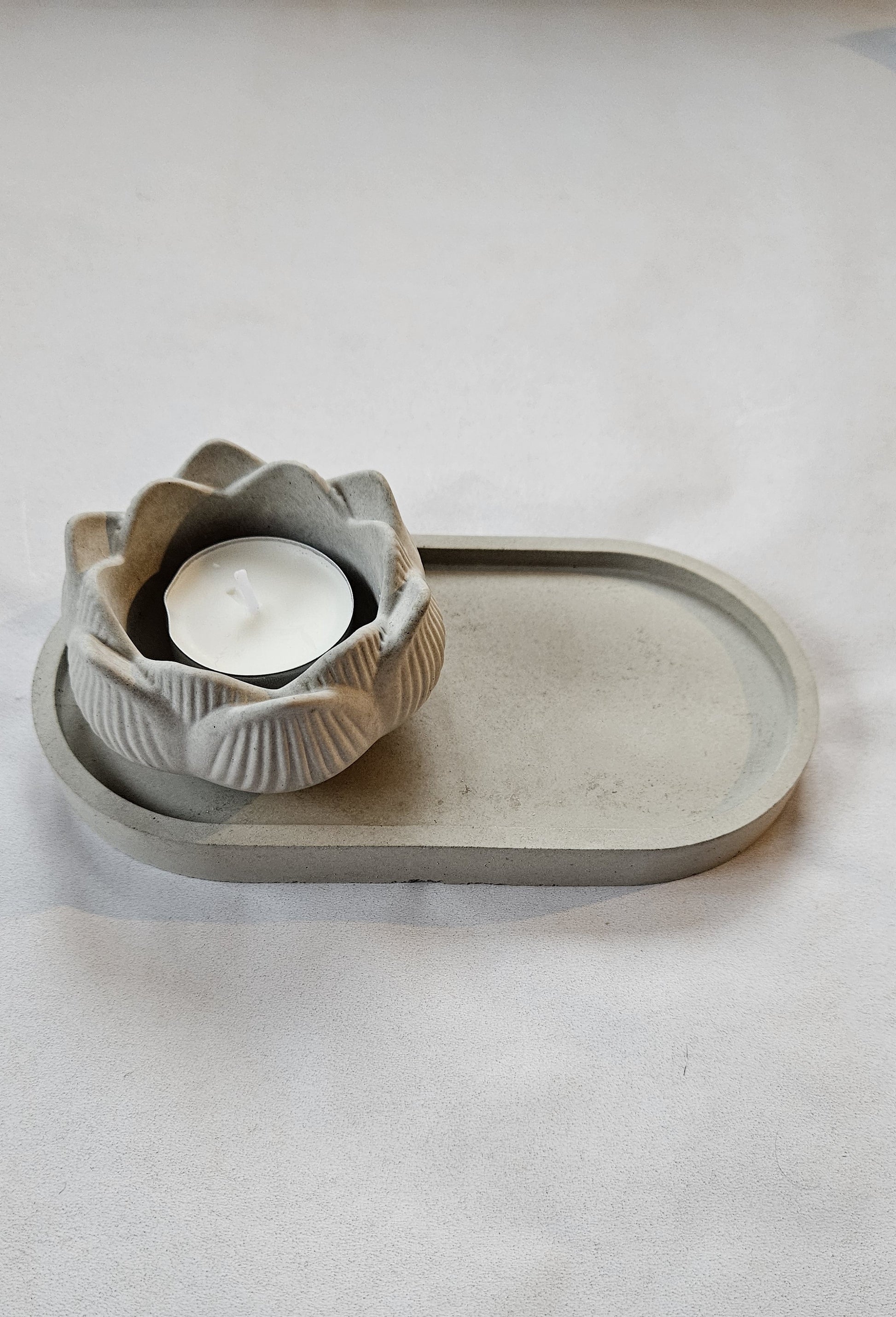 pilka betoninė žvakidė lotosas ant pilko fono