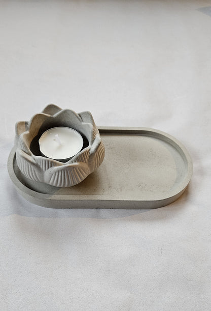 pilka betoninė žvakidė lotosas ant pilko fono