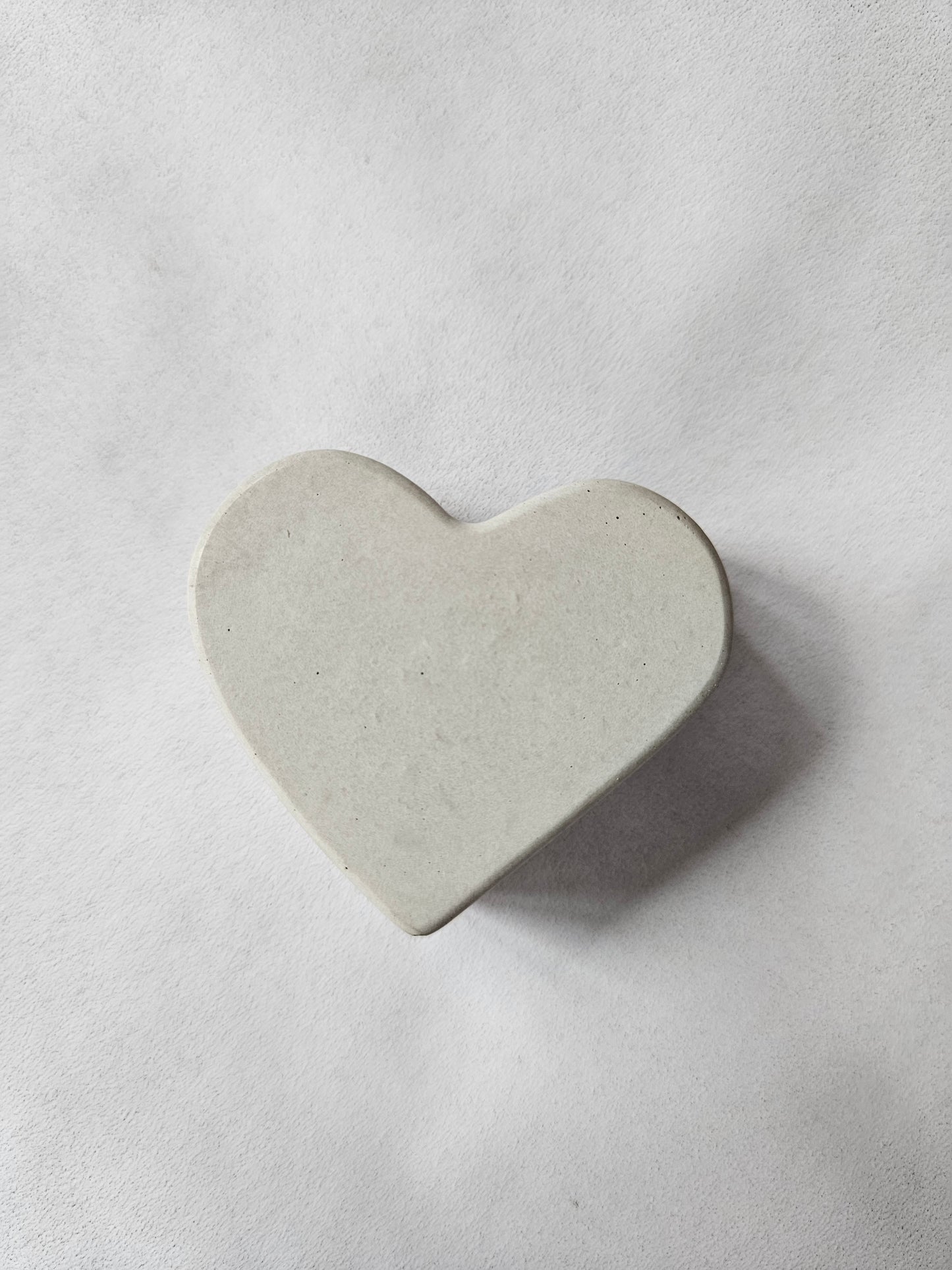 širdelės formos betoninis laikiklis atvirukui pilkame fone