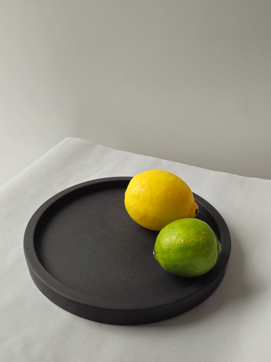 juodas betoninis padėklas su citrina ir laimu