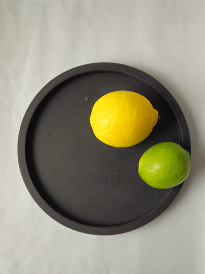 juodas betoninis padėklas su citrina ir laimu